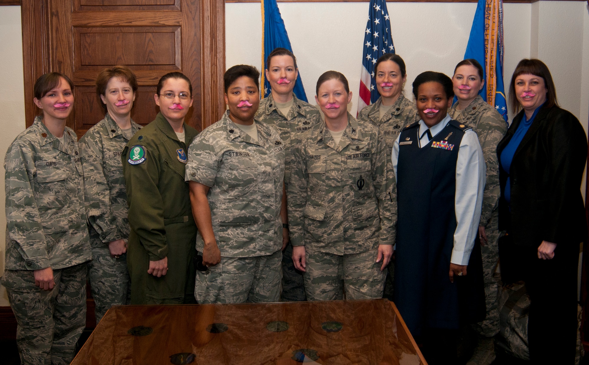 Col. Tracey Hayes, 90th Missile Wing commander, and female 90th MW leaders pose wearing pink mustaches in the wing commander’s office March 19, 2014. While they are unable to grow their own mustaches, these women found a way to show their support for Mustache March. (U.S. Air Force photo by Airman 1st Class Jason Wiese)