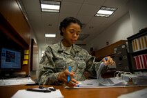 Tech. Sgt. Katrina K. Strother, NCO in charge of command post training from the 5th Bomb Wing Command Post, looks through binders at Minot Air Force Base, N.D., March 9, 2014. Strother was awarded the title of 5BW NCO of the Year Feb. 24, 2014, along with the Air Force Global Strike Command’s Command Post Unit Level NCO of the year award, March 10, 2014. (U.S. Air Force photos/ Senior Airman Brittany Y. Auld)