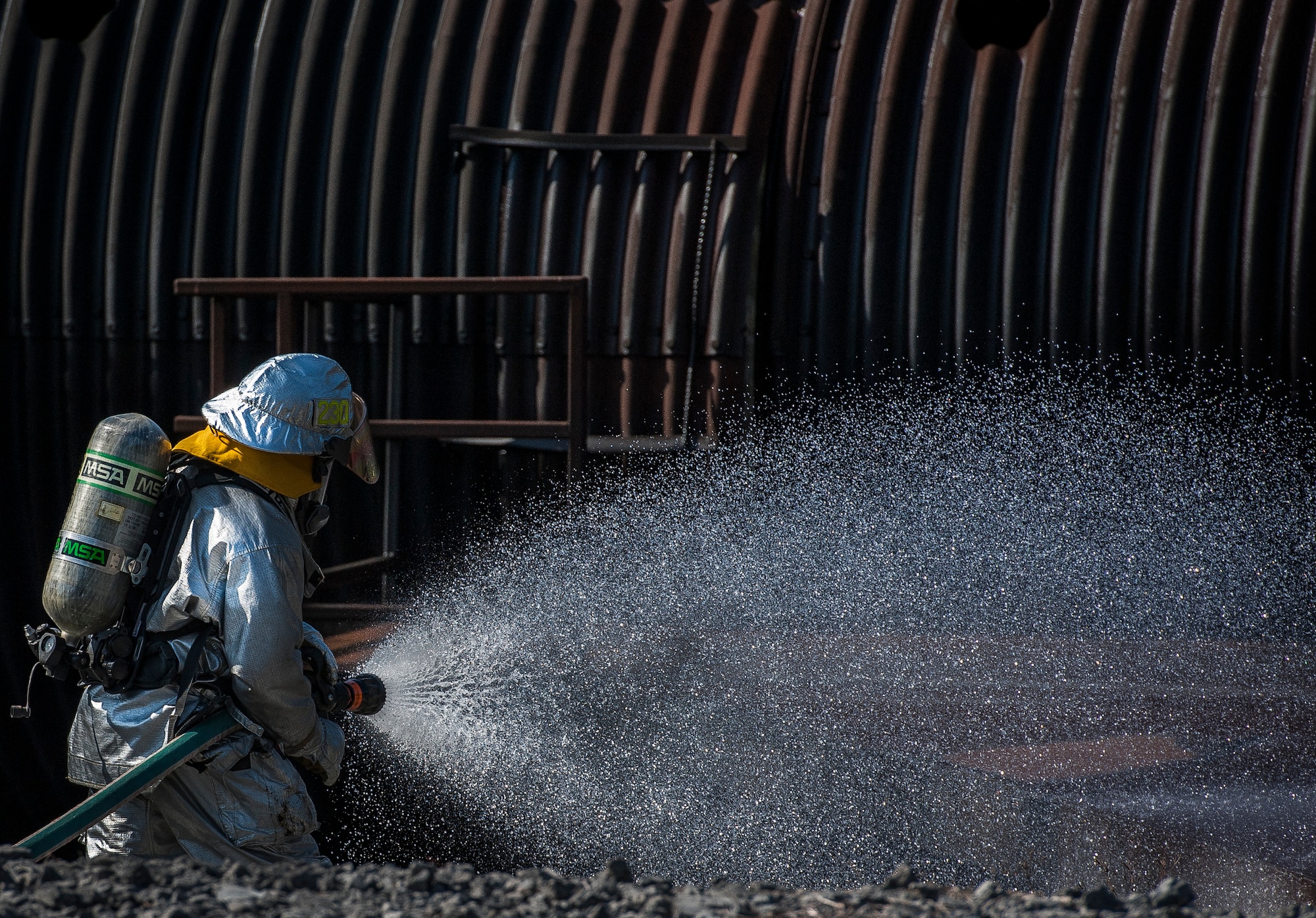 Marcus Shephard, 628th Civil Engineering Squadron lead fire fighter hoses down a training aircraft model during a Mass Casualty Exercise March 28, 2014, at JB Charleston – Air Base, S.C. The purpose of the exercise was to test the ability of JB Charleston first responders in the event of an emergency. (U.S. Air Force photo / Senior Airman Tom Brading)