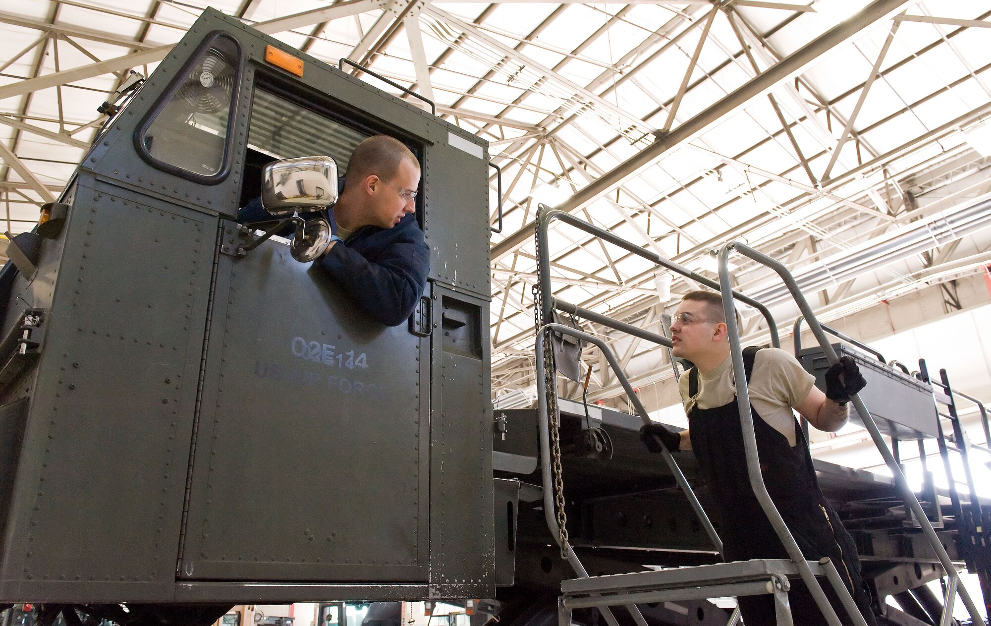 Staff Sgt. Matthew Akers, left, and Airman 1st Class Jacob Parks, right, both from the 436th Logistics Readiness Squadron, discuss the positioning of the Tunner 60K aircraft cargo loader/transporter platform April 1, 2014, at the MHE maintenance section on Dover Air Force Base, Del. Akers and Parks took about 30 minutes to reposition each of the 10 two-wheeled bogie assemblies. (U.S. Air Force photo/Roland Balik)
