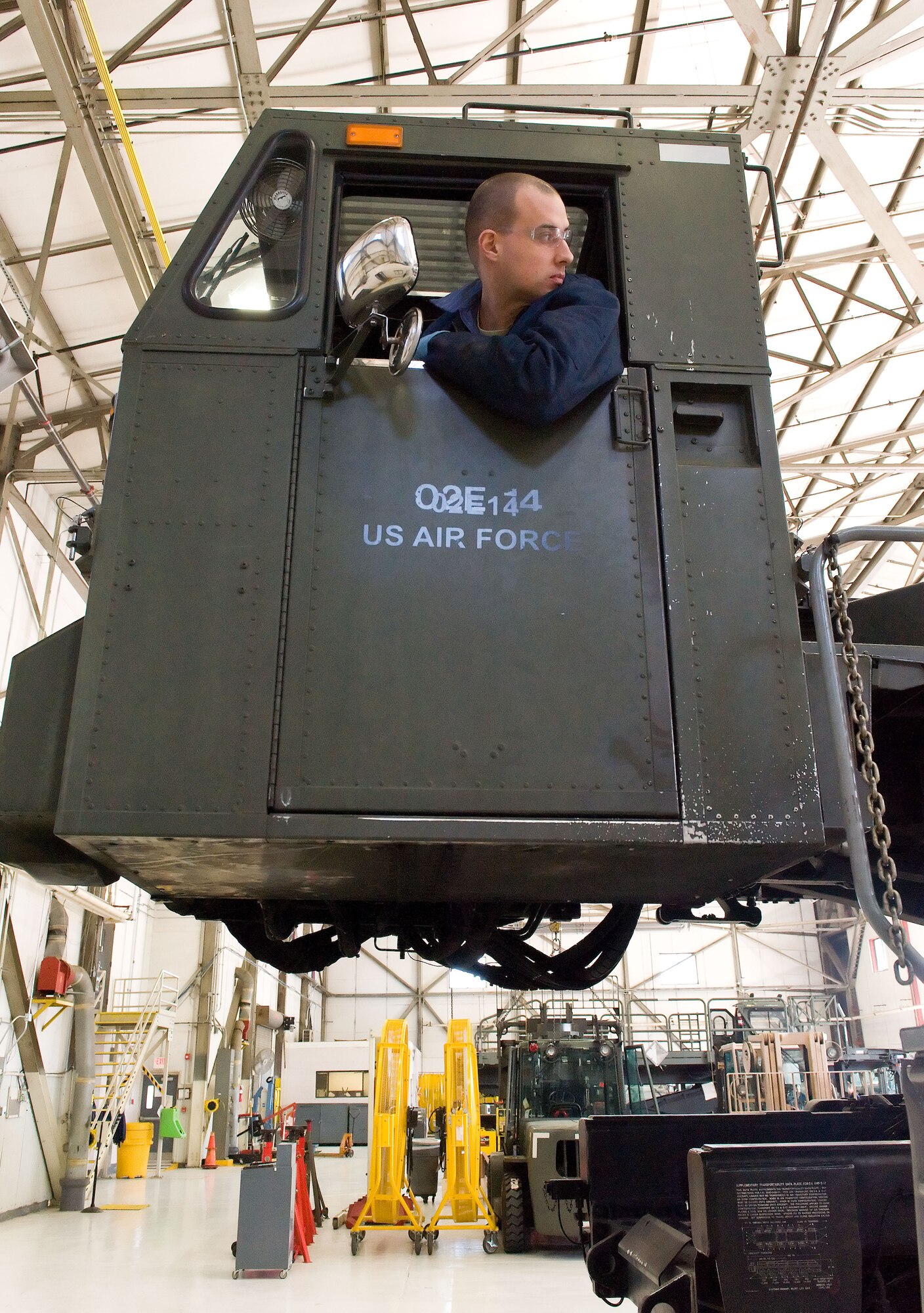 Staff Sgt. Matthew Akers, 436th Logistics Readiness Squadron material handling equipment maintenance journeyman, looks at his spotter as he lowers a Tunner 60K aircraft cargo loader/transporter platform April 1, 2014, at the MHE maintenance section on Dover Air Force Base, Del. Raising and lowering the cargo platform is required numerous times in order to reposition each of the 10 bogie assemblies prior to shipment. (U.S. Air Force photo/Roland Balik)
