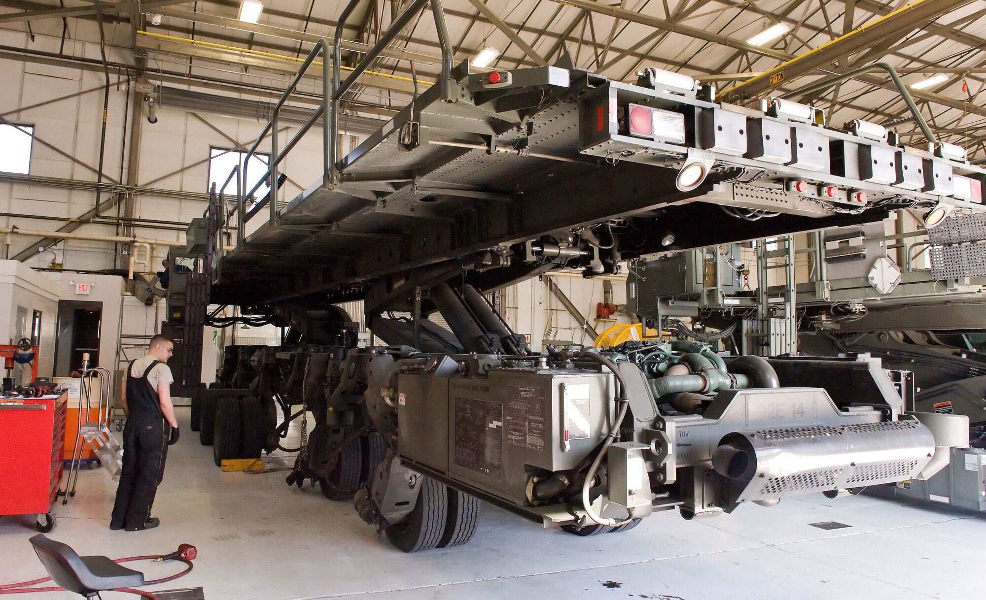 Airman 1st Class Jacob Parks, watches the bogie assemblies as Staff Sgt. Matthew Akers, both from the 436th Logistics Readiness Squadron, lowers the Tunner 60K aircraft cargo loader/transporter into position April 1, 2014, at the MHE maintenance section on Dover Air Force Base, Del. Akers and Parks prepared the Tunner's 10 bogie assemblies, catwalks and driver cab for shipment to the manufacturer for rebuild. (U.S. Air Force photo/Roland Balik)
