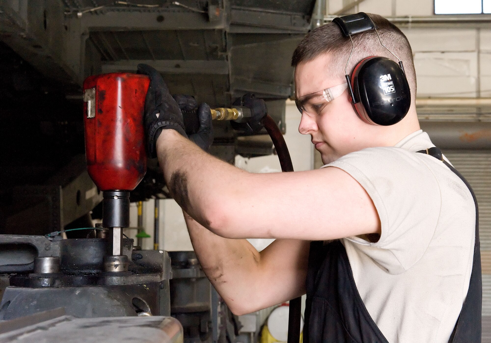 Airman 1st Class Jacob Parks, 436th Logistics Readiness Squadron material handling equipment maintenance apprentice, tightens one of four top Tunner 60K aircraft cargo loader/transporter bogie assembly bolts April 1, 2014, at the MHE maintenance section on Dover Air Force Base, Del. Parks used a pneumatic wrench to tighten the bolts that secure it to the frame of the cargo loader. (U.S. Air Force photo/Roland Balik)

