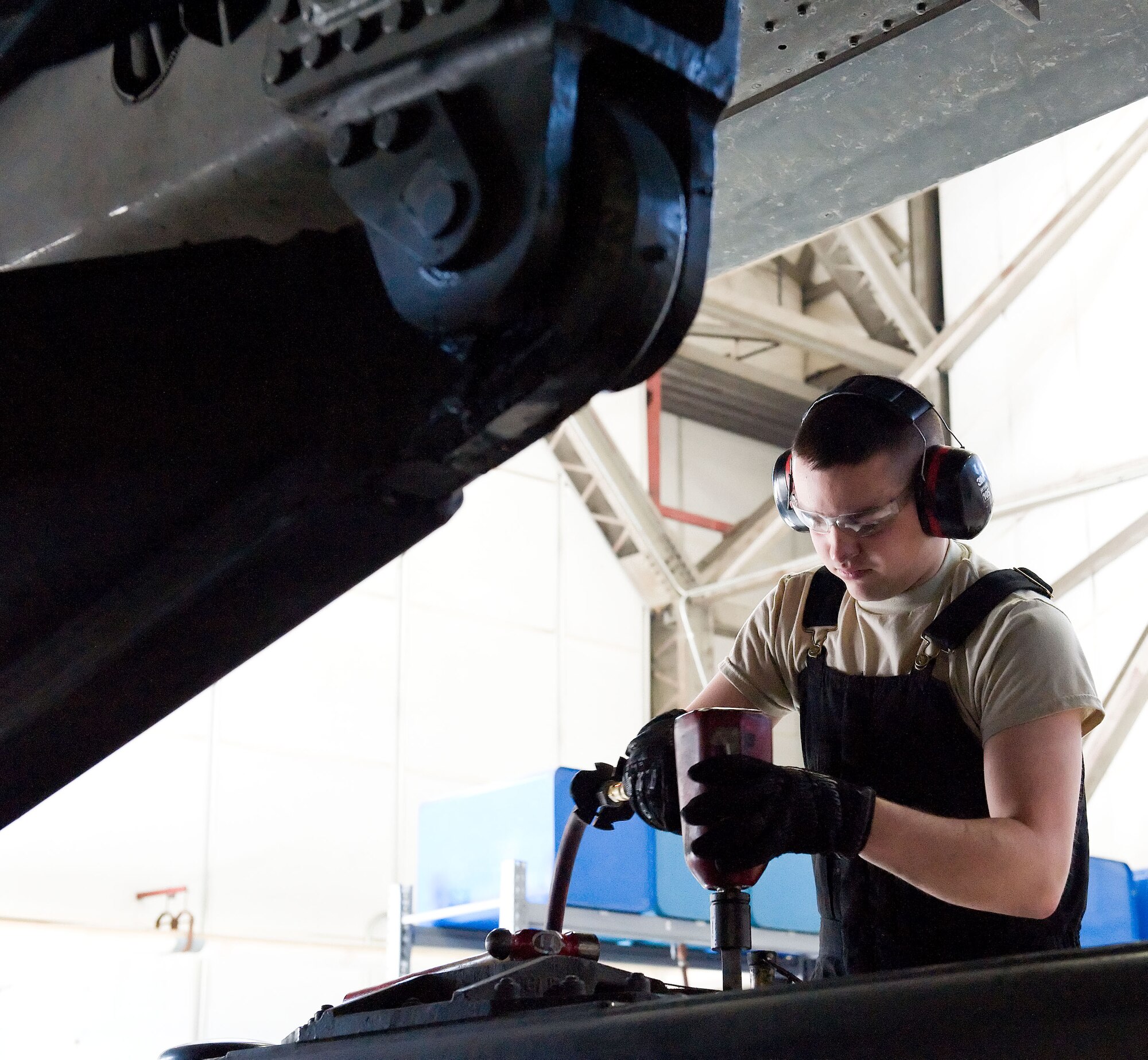 Airman 1st Class Jacob Parks, 436th Logistics Readiness Squadron material handling equipment maintenance apprentice, tightens a Tunner 60K aircraft cargo loader/transporter bogie assembly bolt April 1, 2014, at the MHE maintenance section on Dover Air Force Base, Del. Parks used a pneumatic wrench to tighten the six bolts that secure it to the frame of the cargo loader. (U.S. Air Force photo/Roland Balik)
