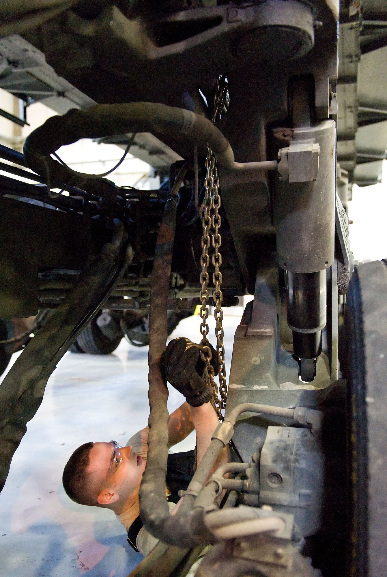 Airman 1st Class Jacob Parks, 436th Logistics Readiness Squadron material handling equipment maintenance apprentice, secures a chain to a Tunner 60K aircraft cargo loader/transporter bogie assembly April 1, 2014, at the MHE maintenance section on Dover Air Force Base, Del. Parks used the chain to hold the bogie assembly in place prior to removing the bogie bolts. (U.S. Air Force photo/Roland Balik)
