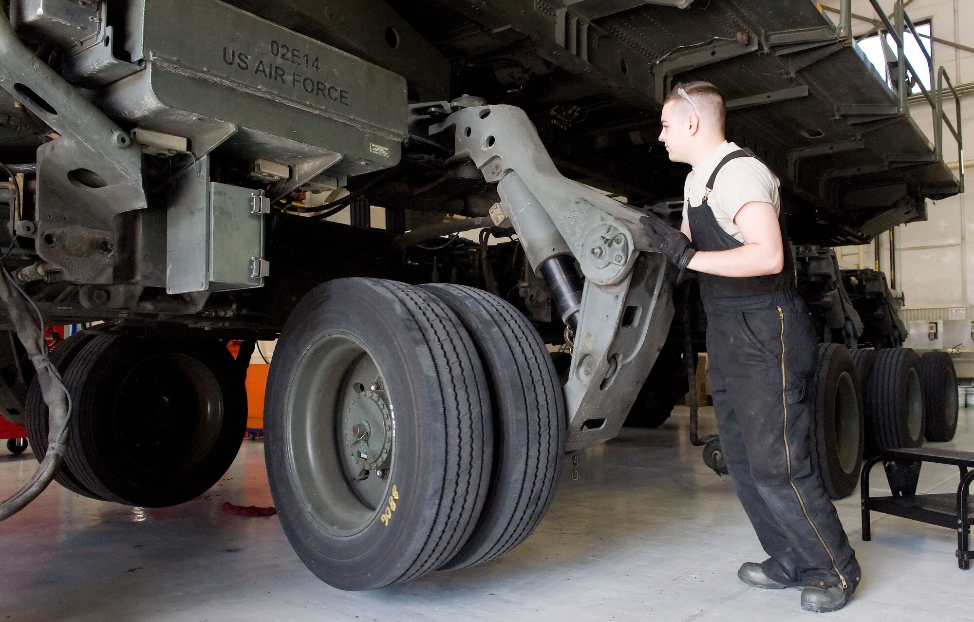 Airman 1st Class Jacob Parks, 436th Logistics Readiness Squadron material handling equipment maintenance apprentice, rotates a Tunner 60K aircraft cargo loader/transporter bogie assembly April 1, 2014, at the MHE maintenance section on Dover Air Force Base, Del. Parks rotated each of the cargo loader's 10 bogie assemblies 180 degrees as part of the shipment preparation. (U.S. Air Force photo/Roland Balik)
