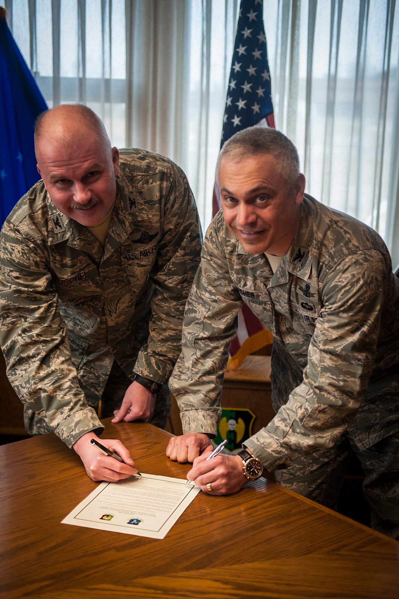(from left to right) Col. Jeffrey Neischel, 5th Bomb Wing vice commander and Col. Robert Vercher, 91st Missile Wing commander, sign the Month of the Military Child, National Child Abuse Prevention, Alcohol Awareness, and Sexual Assault Awareness Month Proclamation at Minot Air Force Base, N.D., March 31, 2014. The proclamation stated that  the month of April 2014, will be the Month of the Military Child, Child Abuse Prevention, Alcohol Awareness, and Sexual Assault Awareness Month at MAFB, and that Neischel and Vercher urge it's appropriate recognition thereof.