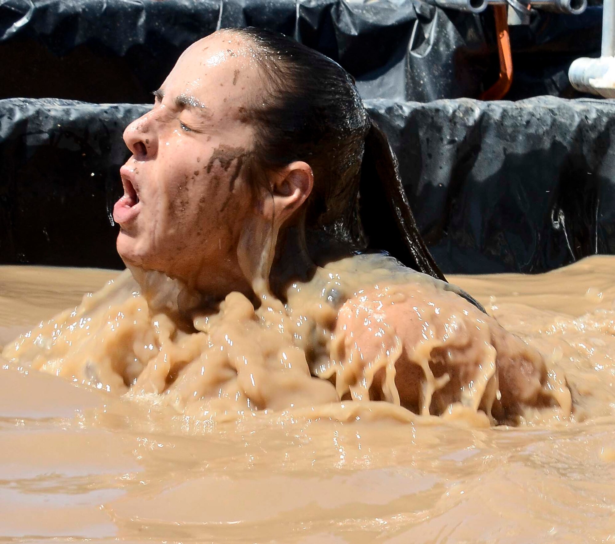 Master Sgt. Larita Trudell, 12th Air Force (Air Forces Southern) Commander Support Staff Superintendent, emerges from underneath water during a portion of the Hard Charge Televised Obstacle Mission at the Pima County Fairgrounds in Tucson, Ariz., on March 29. Climbing, crawling and sprinting were a few of the many ways the members form 12th AF passed though the rigorous four-mile 37-obstacle course. (U.S. Air Force photo by Staff Sgt. Adam Grant/Released)