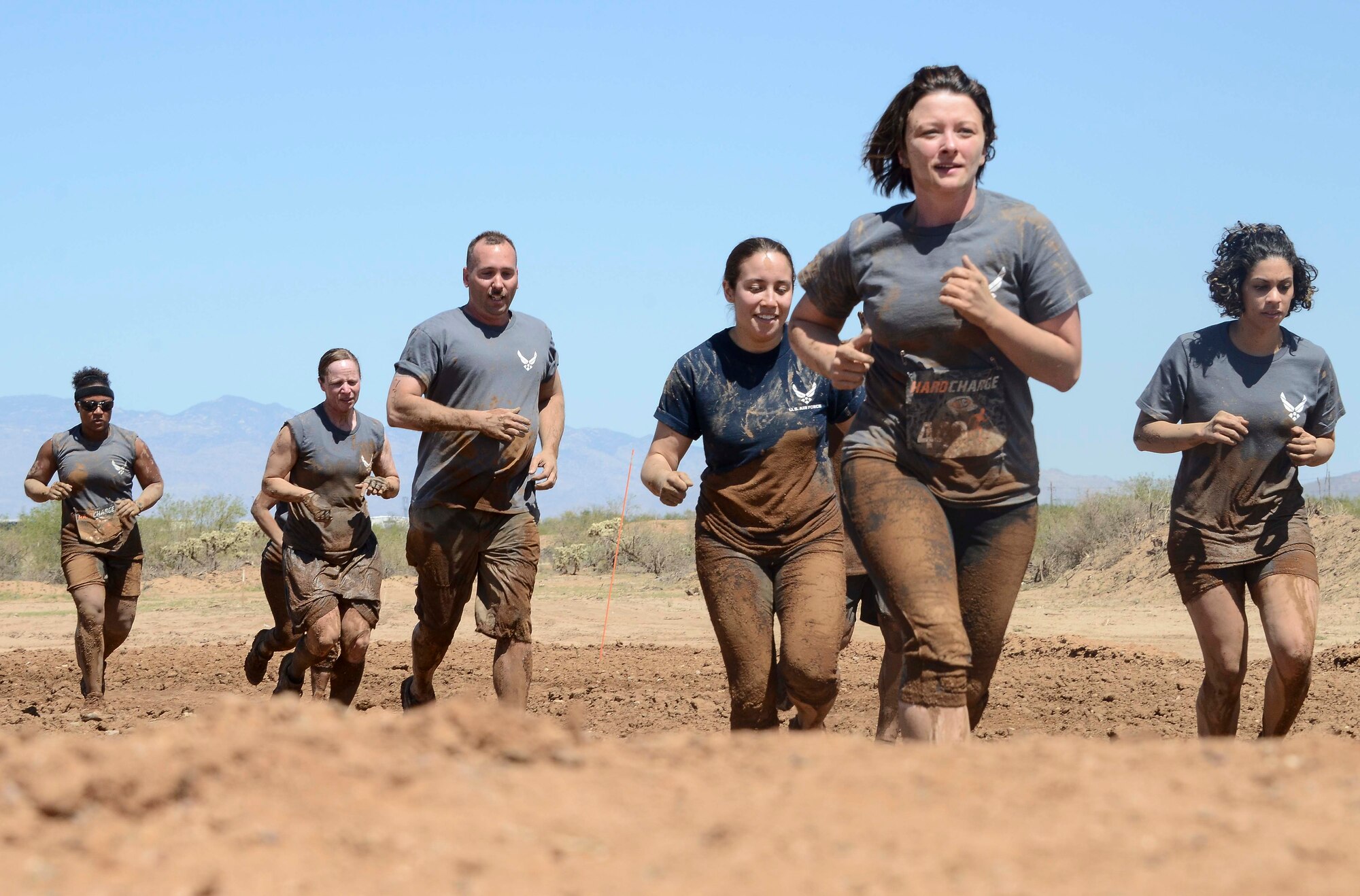 Members from 12th Air Force (Air Forces Southern) jog to their next obstacle during the Hard Charge Televised Obstacle Mission at the Pima County Fairgrounds in Tucson, Ariz., on March 29. The team of 11 members completed the four mile course with of obstacles designed to utilize a mix of strength, stamina, balance, and body awareness  that pushed participants to both mental and physical fatigue. (U.S. Air Force photo by Staff Sgt. Adam Grant/Released)