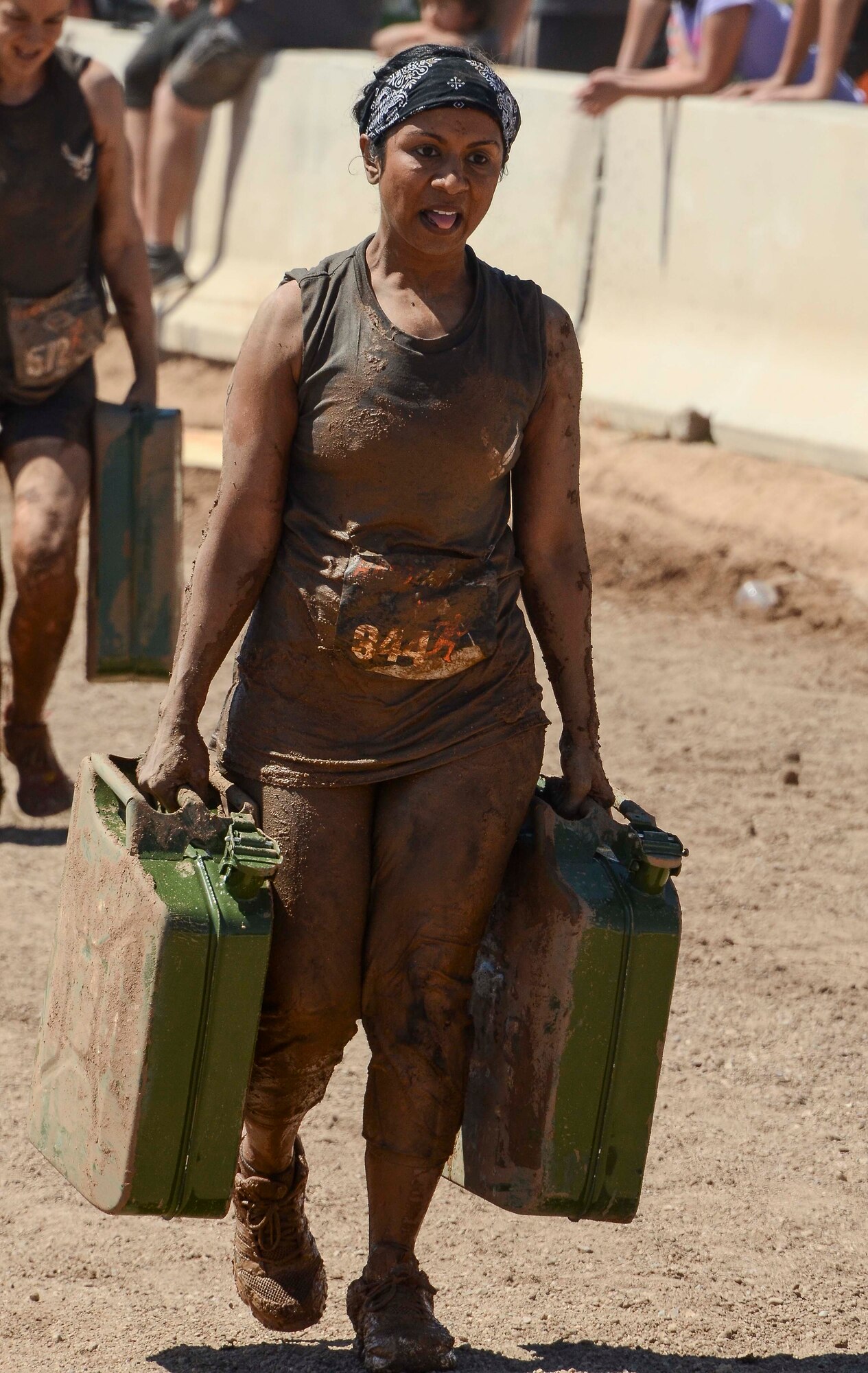 Irene Ramey, 12th Air Force (Air Forces Southern) Services Chief, carries jugs filled with water during her team’s last stretch of the Hard Charge Televised Obstacle Mission at the Pima County Fairgrounds in Tucson, Ariz., on March 29. The team of 11 members completed the four mile course with of obstacles designed to utilize a mix of strength, stamina, balance, and body awareness that pushed participants to both mental and physical fatigue. (U.S. Air Force photo by Staff Sgt. Adam Grant/Released)