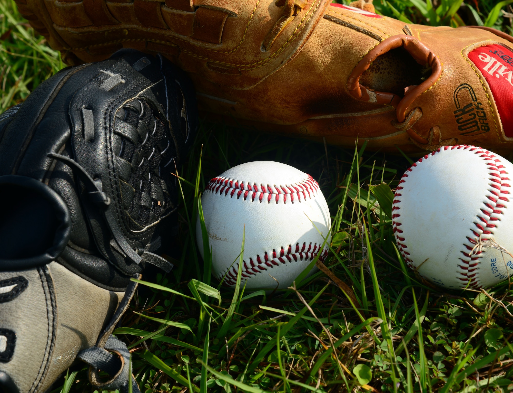 Baseballs and baseball gloves lay on the ground during the youth baseball opening ceremony at MacDill Air Force Base, Fla., March 29, 2014. A total of 10 teams came out to kick off the youth baseball season. (U.S. Air Force photo by Airman 1st Class Tori Schultz/Released)