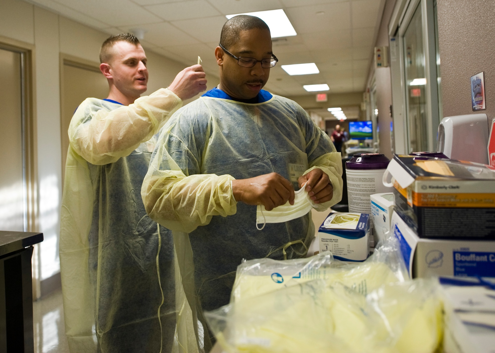 U.S. Air Force Staff Sgt. Frank Yuvan, 99th Medical Operations Squadron medical technician and Tech. Sgt. Chuck Broadus, NCO in charge of the Emergency Room, don their gowns before a burn patient visit March 28, 2014, at University Medical Center, Las Vegas. UMC’s, Lions Burn Care Center houses Nevada’s only burn care facility. (U.S. Air Force photo by Senior Airman Jason Couillard)