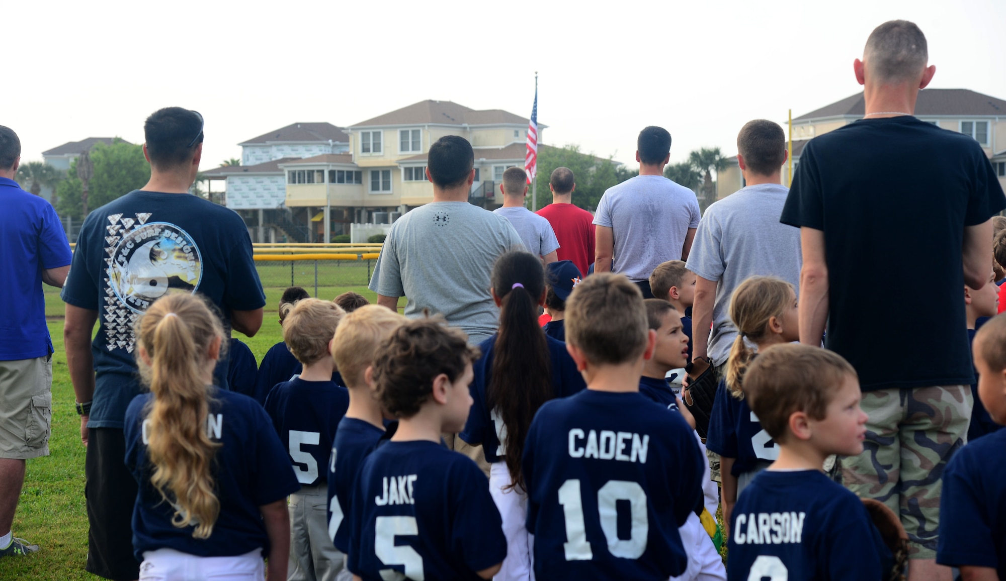 Members with the youth baseball program stand for the National Anthem during the opening ceremony at MacDill Air Force Base, Fla., March 29, 2014. A total of 10 teams came out to kick off the youth baseball season. (U.S. Air Force photo by Airman 1st Class Tori Schultz/Released)