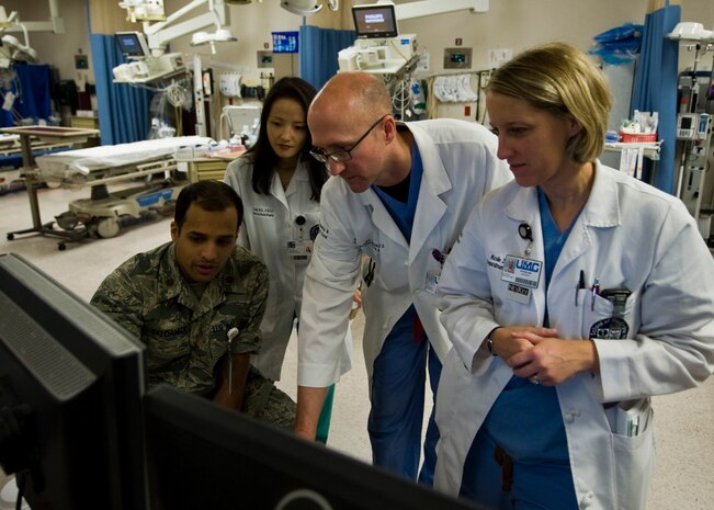 U.S. Air Force surgeons assigned to the Mike O'Callaghan Federal Medical Center, Nellis Air Force Base discuss a patient’s medical records March 28th, 2014, at University Medical Center, Las Vegas. MOFMC Airmen are provided the opportunity to maintain their medical expertise by participating in a joint venture with UMC. (U.S. Air Force photo by Senior Airman Jason Couillard)