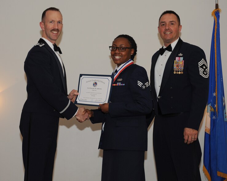Senior Airman Charday Jefferson, 154th Training Squadron, Little Rock Air Force Base, Ark., receives an Airman Leadership School graduation certificate from Col. Leland Bohannon, 2nd Bomb Wing vice commander, during the ALS Class 14-3 Graduation on Barksdale AFB, La., March 27, 2014. (U.S. Air Force photo/Senior Airman Benjamin Gonsier)
