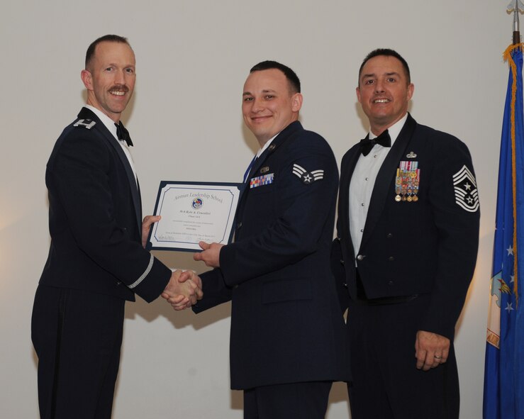 Senior Airman Kyle Cracolici, 2nd Aircraft Maintenance Squadron, receives an Airman Leadership School graduation certificate from Col. Leland Bohannon, 2nd Bomb Wing vice commander, during the ALS Class 14-3 Graduation on Barksdale Air Force Base, La., March 27, 2014. (U.S. Air Force photo/Senior Airman Benjamin Gonsier)