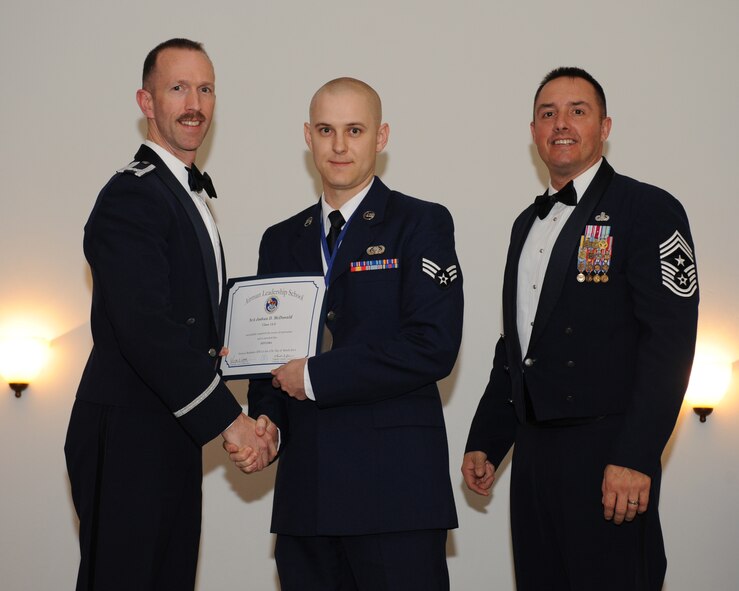 Senior Airman Joshua McDonald, 2nd Communications Squadron, receives an Airman Leadership School graduation certificate from Col. Leland Bohannon, 2nd Bomb Wing vice commander, during the ALS Class 14-3 Graduation on Barksdale Air Force Base, La., March 27, 2014. (U.S. Air Force photo/Senior Airman Benjamin Gonsier)