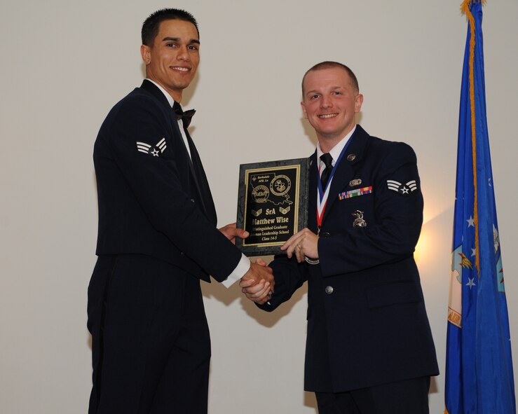 Senior Airman Matthew Wise, 2nd Security Forces Squadron, receives the Distinguished Graduate Award from Senior Airman Jorge Garcia-Gonzalez, 2nd Force Support Squadron, during the Airman Leadership School Class 14-3 Graduation on Barksdale Air Force Base, La., March 27, 2014. (U.S. Air Force photo/Senior Airman Benjamin Gonsier)