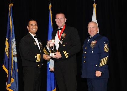 Representing the Coast Guard for award presentations during the Joint Base San Antonio Annual Awards Banquet March 29 are Commander Gene Anzano, left, and Master Chief Intelligence Specialist Alan Paul, right. Petty Officer 1st Class Joseph Gribbins, center, from the Coast Guard Recruiting Office San Antonio, received the NCO of the Year Award. (U.S. Air Force photo by Melissa Peterson)
