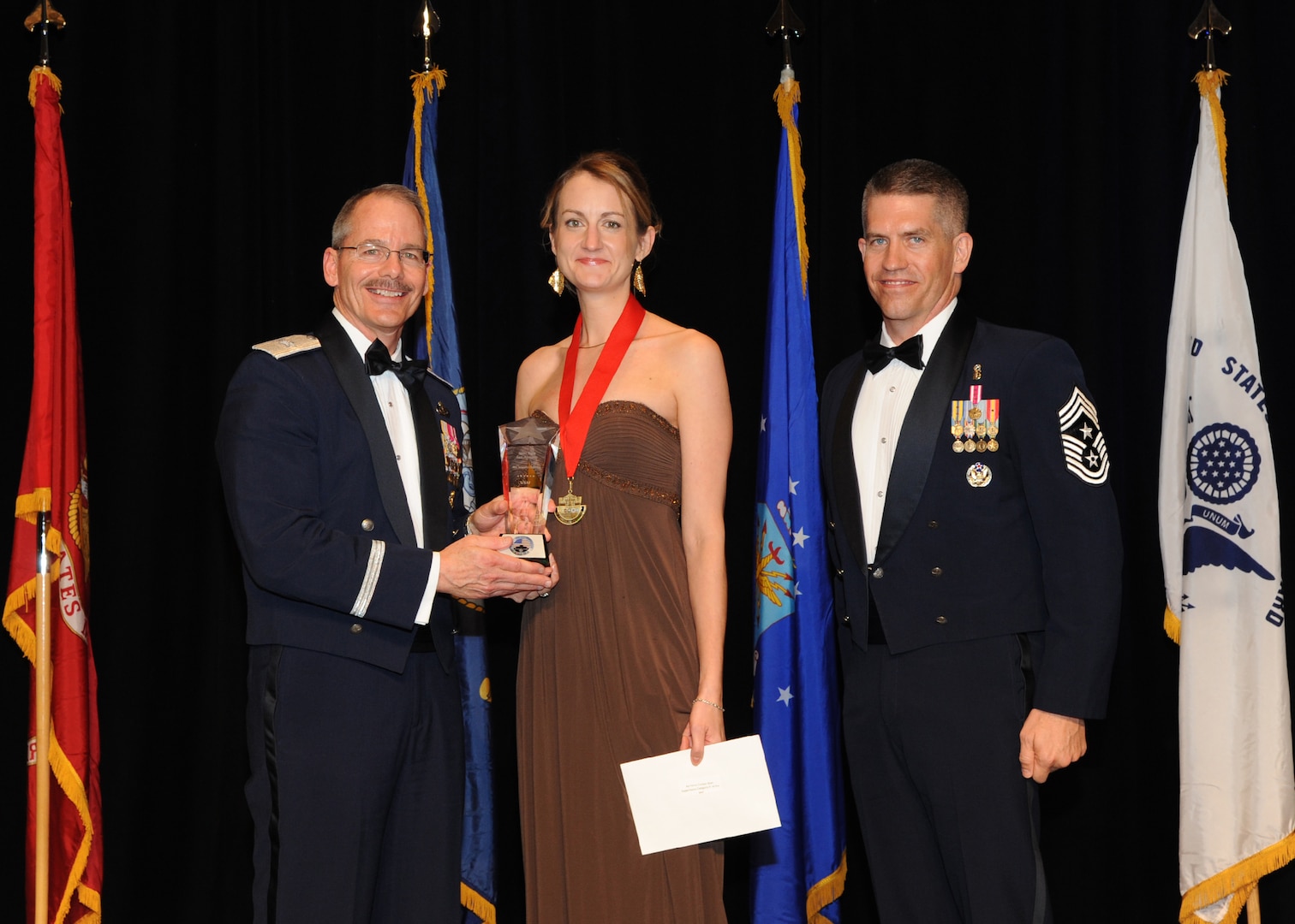 Representing the Air Force for award presentations during the Joint Base San Antonio Annual Awards Banquet March 29 are Brig. Gen. Bob Labrutta, left, and Chief Master Sgt. Alex Perry, right. Jacquelyn Christilles, center, from the 502nd Air Base Wing, received the Civilian Non-Supervisory Category II of the Year Award. (U.S. Air Force photo by Melissa Peterson)
