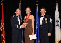 Representing the Air Force for award presentations during the Joint Base San Antonio Annual Awards Banquet March 29 are Brig. Gen. Bob Labrutta, left, and Chief Master Sgt. Alex Perry, right. Jacquelyn Christilles, center, from the 502nd Air Base Wing, received the Civilian Non-Supervisory Category II of the Year Award. (U.S. Air Force photo by Melissa Peterson)