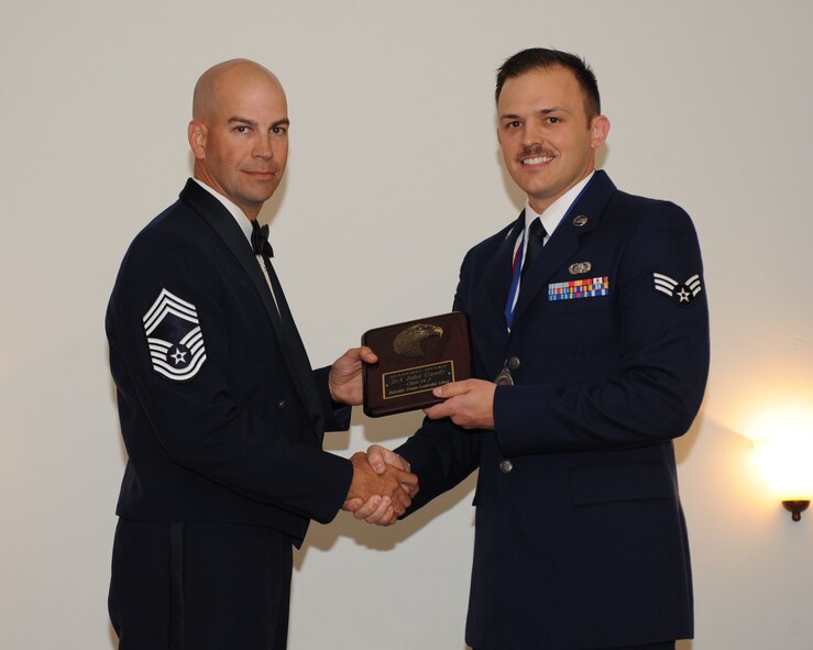 Senior Airman John Gandy, 2nd Communications Squadron, receives the Academic Award from Chief Master Sgt. Brian Huber, 2nd Force Support Squadron, during the Airman Leadership School Class 14-3 Graduation on Barksdale Air Force Base, La., March 27, 2014. (U.S. Air Force photo/Senior Airman Benjamin Gonsier)
