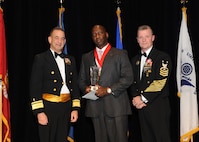 Representing the Navy for award presentations during the JBSA Annual Awards Banquet March 29 are Rear Adm. Bill Roberts, left, and Command Master Chief Petty Officer Christopher Angstead, right. Tony Cloud, center, from the Navy Technical Training Center, received the Civilian Supervisory Category II of the Year Award. (U.S. Air Force photo by Melissa Peterson)
