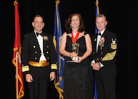 Representing the Navy for award presentations during the Joint Base San Antonio Annual Awards Banquet March 29 are Rear Adm. Bill Roberts, left, and Command Master Chief Petty Officer Christopher Angstead, right. Betsey Griffis, center, from the Navy Operational Support Center, received the Civilian Non-Supervisory Category I of the Year Award. (U.S. Air Force photo by Melissa Peterson)