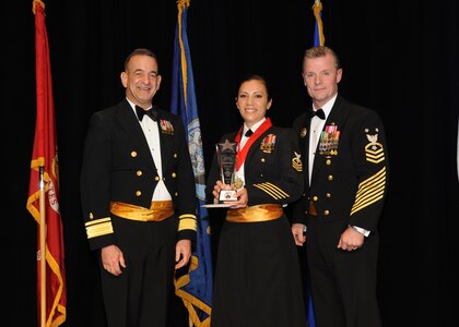Representing the Navy for award presentations during the Joint Base San Antonio Annual Awards Banquet March 29 are Rear Adm. Bill Roberts, left, and Command Master Chief Petty Officer Christopher Angstead, right. Chief Petty Officer Emilia Guerrero, center, from the Center for Security Forces, received the Large Unit Category First Sergeant of the Year Award. (U.S. Air Force photo by Melissa Peterson)