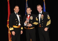 Representing the Navy for award presentations during the Joint Base San Antonio Annual Awards Banquet March 29 are Rear Adm. Bill Roberts, left, and Command Master Chief Petty Officer Christopher Angstead, right. Petty Officer 1st Class Scott Lyons, center, from the Navy Medical Training and Support Center, received the NCO of the Year Award. (U.S. Air Force photo by Melissa Peterson)