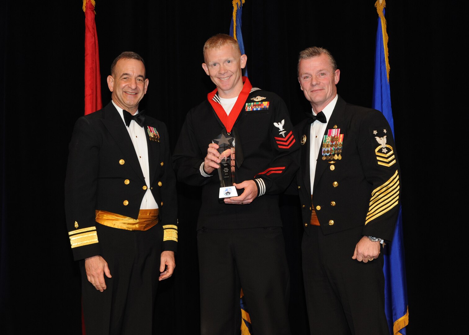 Representing the Navy for award presentations during the Joint Base San Antonio Annual Awards Banquet March 29 are Rear Adm. Bill Roberts, left, and Command Master Chief Petty Officer Christopher Angstead, right. Chief Petty Officer Paul Thompson, center, from the Center for Security Forces, received the Senior Enlisted Member of the Year Award. (U.S. Air Force photo by Melissa Peterson)
