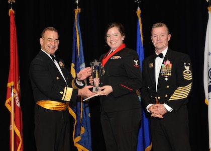Representing the Navy for award presentations during the Joint Base San Antonio Annual Awards Banquet March 29  are Rear Adm. Bill Roberts, left, and Command Master Chief Petty Officer Christopher Angstead, right.  Petty Officer 3rd Class Jacky Floyd, center, from Navy Medicine Training and Support Command, received the Junior Enlisted Member of the Year Award. (U.S. Air Force photo by Melissa Peterson)
