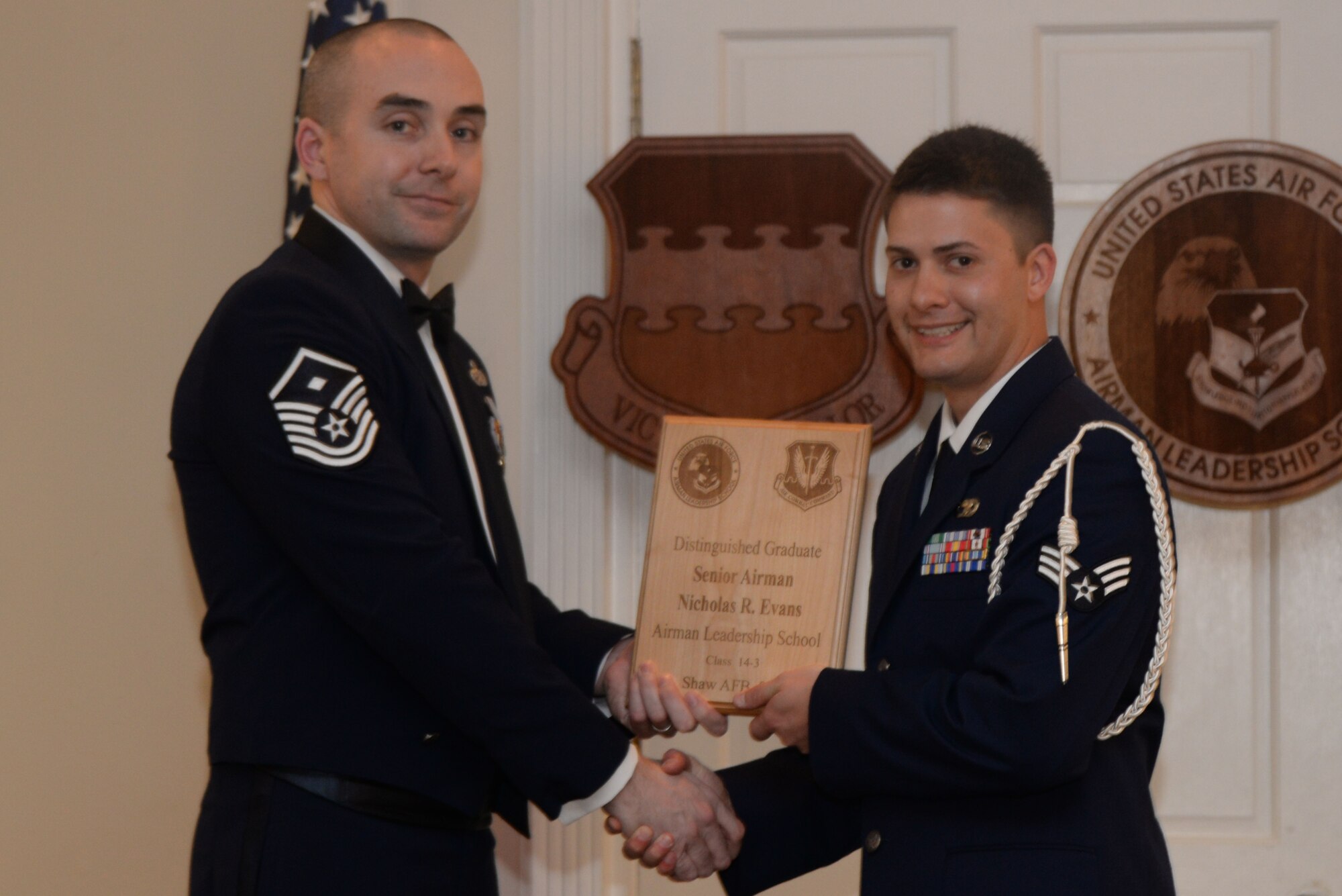 U.S. Air Force Senior Airman Nicholas Evans, 20th Logistic Readiness Squadron, receives a Distinguished Graduate Award from Airman Leadership School class 14-3 from Master Sgt. Master Sgt. Eamon McCracken, 20th Aircraft Maintenance Squadron First Sergeant, Shaw Air Force Base, S.C., March 27, 2014.This award is earned by completing the course with an overall total point accumulation placing the student in the top 10 percent of the class. (U.S. Air Force photo by Airman 1st Class Michael A. Cossaboom/Released) 