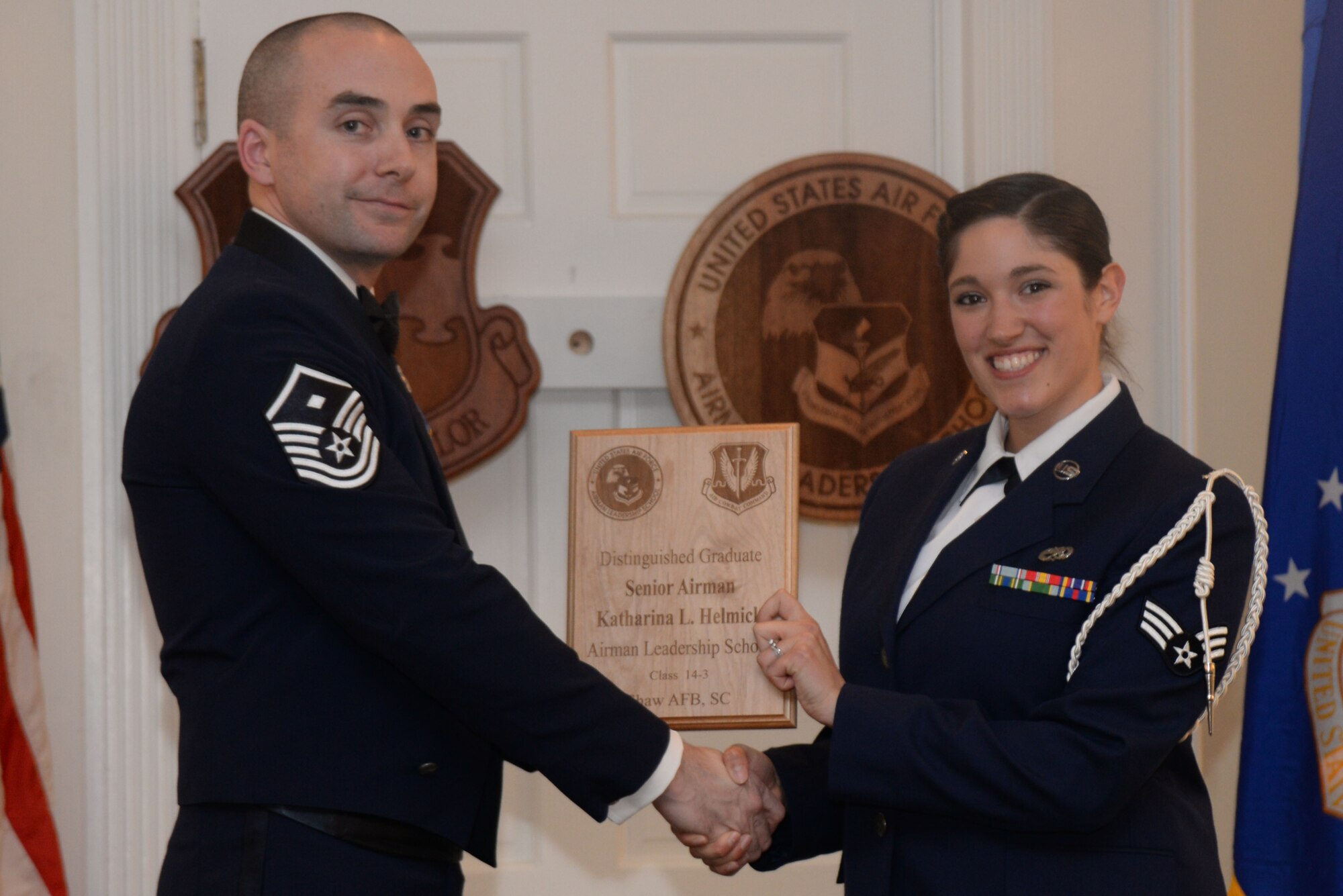 U.S. Air Force Senior Airman Katharina Helmick, 20th Medical Group, receives a Distinguished Graduate Award from Airman Leadership School class 14-3 from Master Sgt. Master Sgt. Eamon McCracken, 20th Aircraft Maintenance Squadron First Sergeant, Shaw Air Force Base, S.C., March 27, 2014. This award is earned by completing the course with an overall total point accumulation placing the student in the top 10 percent of the class. (U.S. Air Force photo by Airman 1st Class Michael A. Cossaboom/Released)