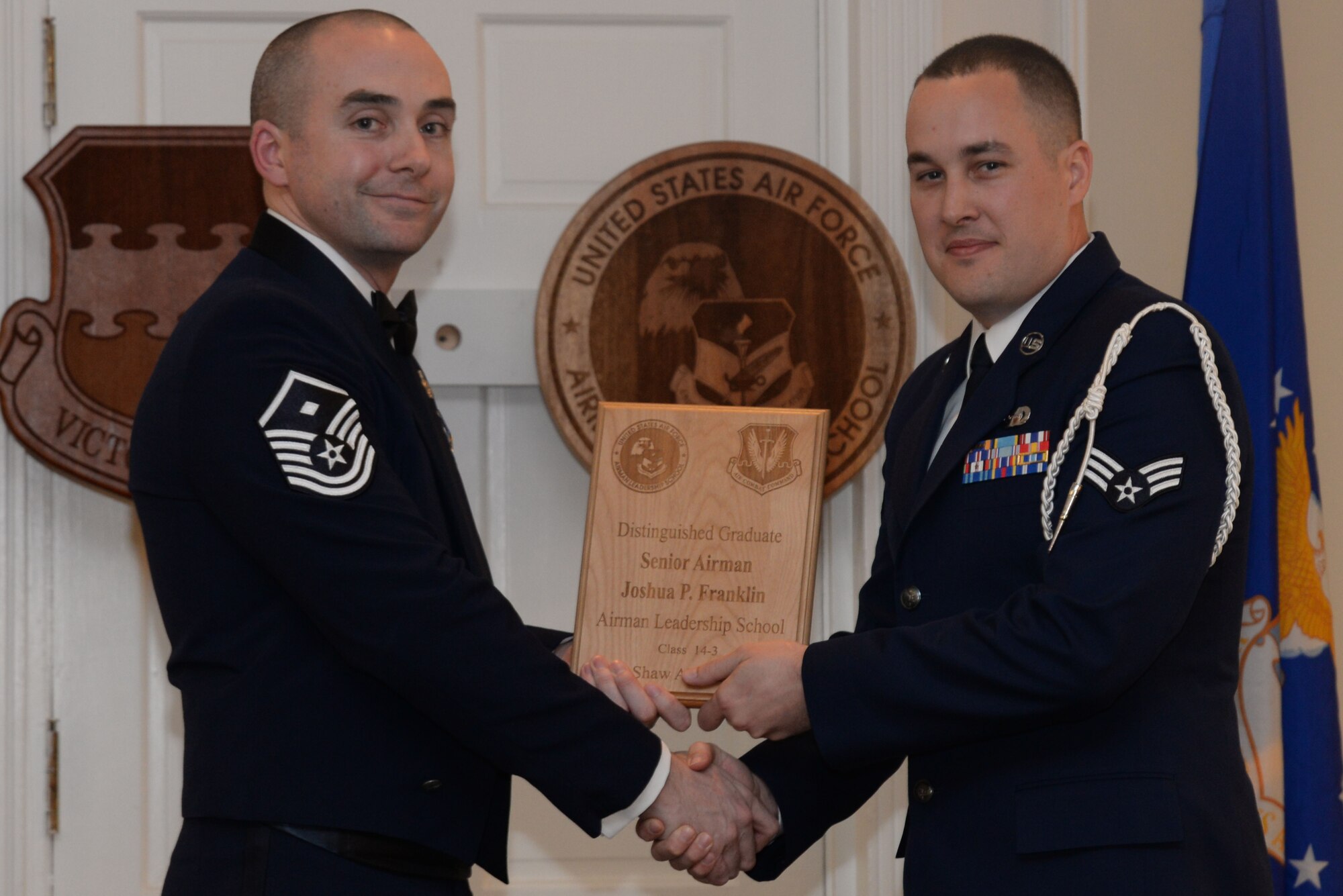 U.S. Air Force Senior Airman Joshua Franklin, 31st Intelligence Squadron, receives a Distinguished Graduate Award from Airman Leadership School class 14-3 from Master Sgt. Eamon McCracken, 20th Aircraft Maintenance Squadron First Sergeant, Shaw Air Force Base, S.C., March 27, 2014. This award is earned by completing the course with an overall total point accumulation placing the student in the top 10 percent of the class. (U.S. Air Force photo by Airman 1st Class Michael A. Cossaboom/Released) 