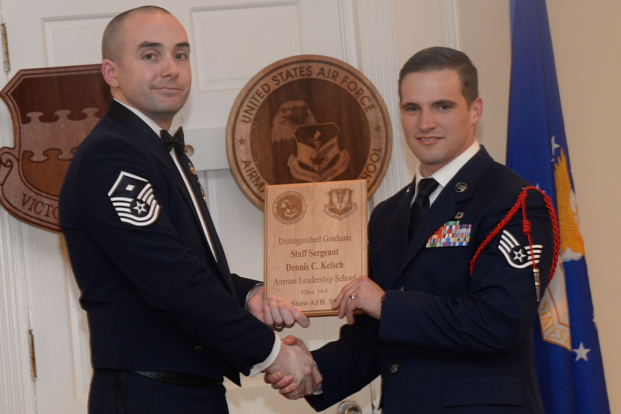 U.S. Air Force Staff Sgt. Dennis Kelsch, 19th Air Support Operations Squadron, receives a Distinguished Graduate Award from Airman Leadership School class 14-3 from Master Sgt. Eamon McCracken, 20th Aircraft Maintenance Squadron First Sergeant, Shaw Air Force Base, S.C., March 27, 2014. This award is earned by completing the course with an overall total point accumulation placing the student in the top 10 percent of the class. (U.S. Air Force photo by Airman 1st Class Michael A. Cossaboom/Released)