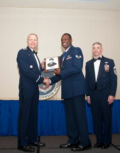 Col. Darren Hartford, 437th Airlift Wing commander, and Chief Master Sgt. Shawn Hughes, 437th AW command chief, present the John L. Levitow Award to Senior Airman Maurice Hargraves, 437th Aircraaft Maintenance Squadron crew chief, during the Airman Leadership School Class graduation March 28, 2014, at Joint Base Charleston - Air Base, S.C. The Levitow award is given for a student's exemplary demonstration of excellence, both as a leader and a scholar. (U.S. Air Force photo/ Staff Sgt. William A. O’Brien) 