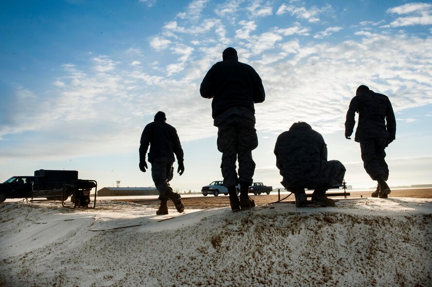 Airmen from the 5th Civil Engineer Squadron install a Precision Approach Path Indicator near taxi-way Echo at Minot Air Force Base, N.D., March 19, 2014. This summer, Minot AFB in coordination with Sundt Construction and the United States Army Corps of Engineers will be performing a $32.8 million runway repair project to replace close to 9,000 feet of the center keel section the PAPI will be used to turn the taxi-way into a temporary emergency runway.  (U.S. Air Force photo/Senior Airman Stephanie Sauberan)
