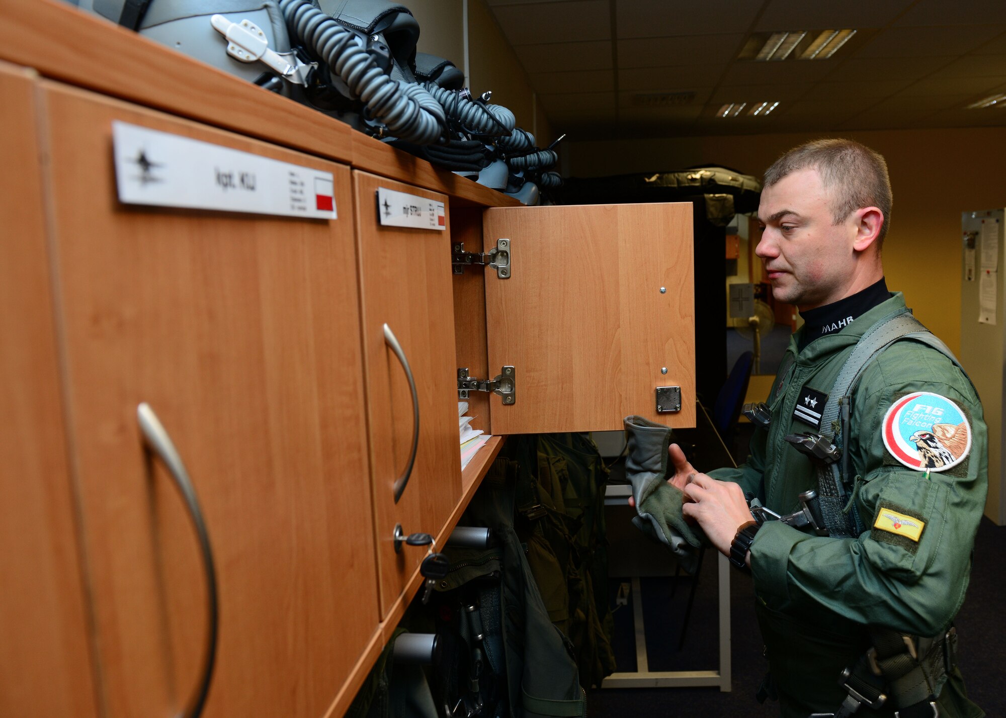 Polish air force Lt. Col. Marcin Modrzewski, 10th Fighter Squadron pilot, starts to put on his aircrew flight equipment, April 1, 2014, prior to the first training sortie between U.S. and Polish air force F-16 Fighting Falcon fighter pilots at Łask Air Base, Poland. The Polish armed forces and approximately 200 U.S. personnel have worked together here since March 13, to increase cooperation and strengthen operational understanding of the other’s military processes, strengthening interoperability with a key NATO ally. (U.S. Air Force photo/Airman 1st Class Ryan Conroy/Released) 