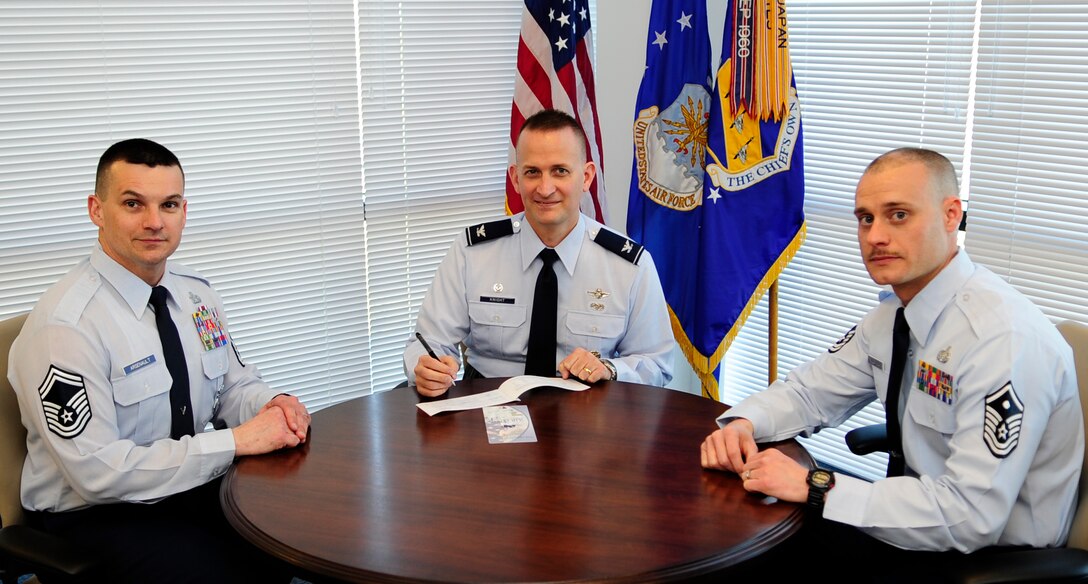 Col. Bill Knight, 11th Wing/Joint Base Andrews commander (center), fills out his donation form to kick off the Air Force Assistance Fund at Joint Base Andrews, Md., March 31, 2014.  Senior Master Sgt. Leonard Arsenault (left) and Master Sgt. Eric Villafana (right) are the 11th Wing AFAF project officers. The campaign runs from March 17 to April 25. (U.S. Air Force photo/Staff Sgt. Torey Griffith)