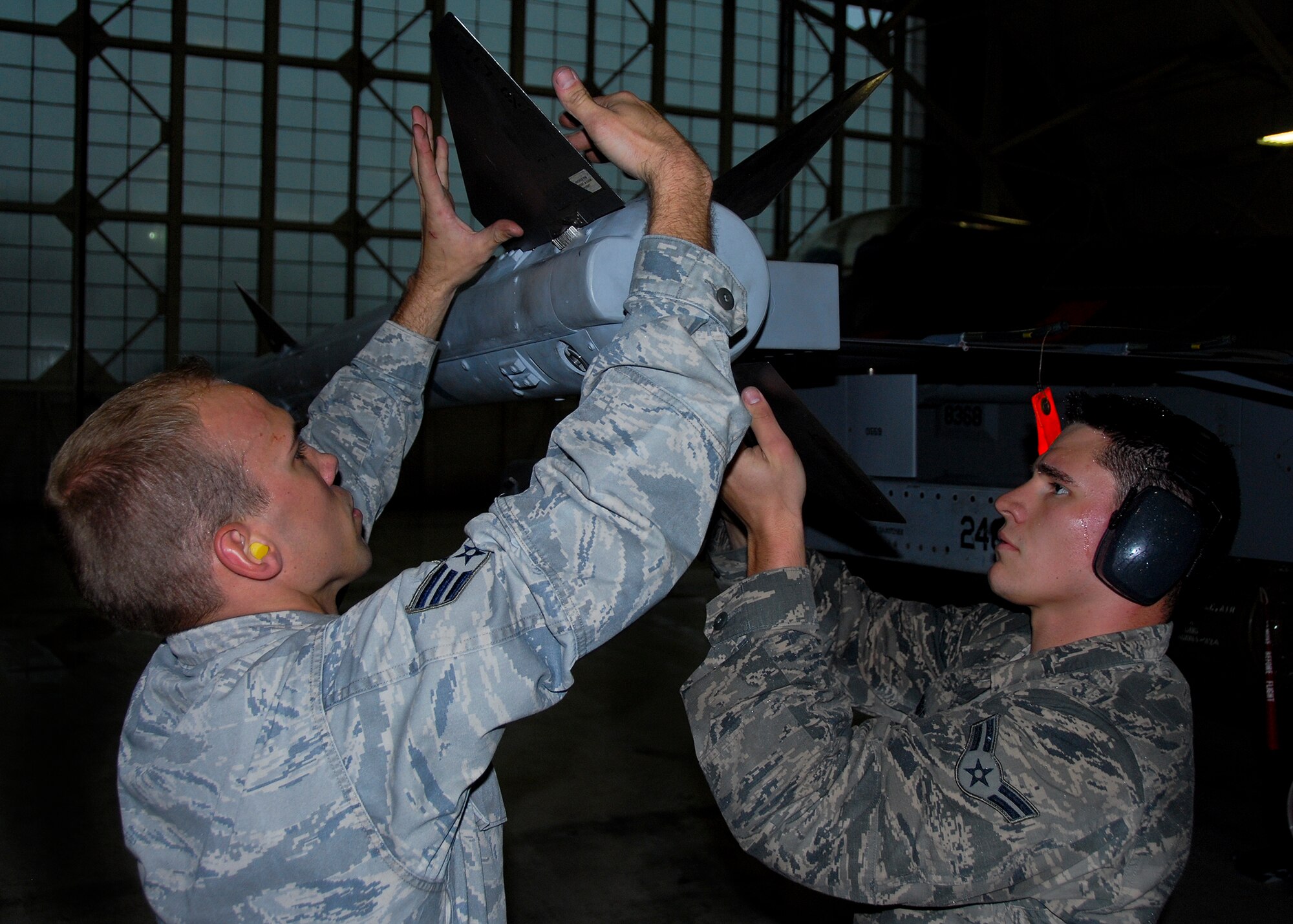 Senior Airman Clayton Turner and Airman 1st Class Jason Moore, of the 96th Aircraft Maintenance Squadron Blue, install AIM-120 fins onto the F-16 Fighter Falcon during the 96th Maintenance Group’s quarterly weapons loadcrew competition March 28 at Eglin Air Force Base, Fla. The Blue AMU team of Turner, Moore and Staff Sgt. Brandon Oliver won the competition. (U.S. Air Force photo/Kevin Gaddie)
