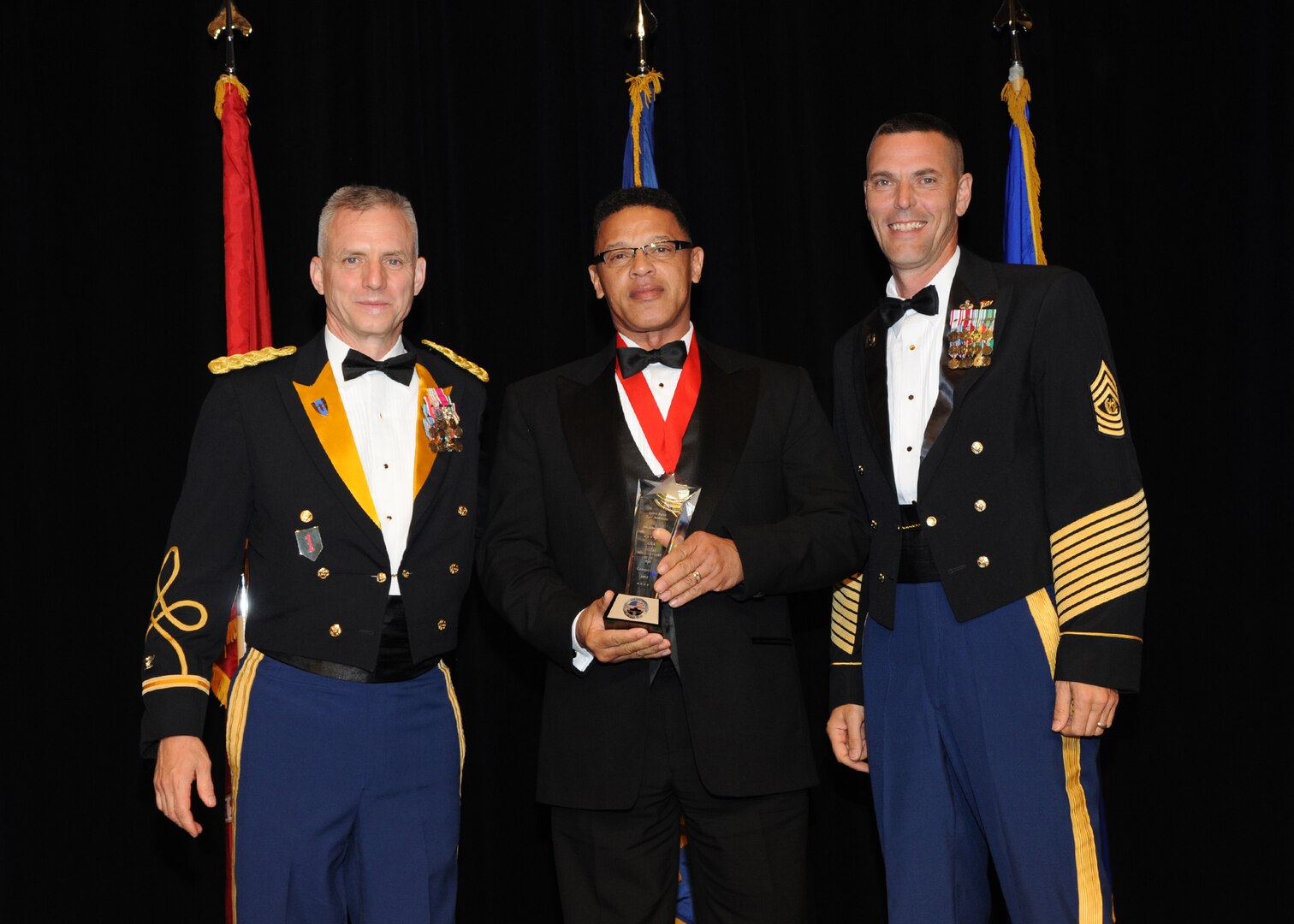 Representing the Army for award presentations during the Joint Base San Antonio Annual Awards Banquet March 29 are Army Col. Jim Chevallier, left, and Command Sgt. Maj. Bryan Witzel, right.  Johnny Gray from Army Support Activity Center, center, received the Civilian Non-Supervisory Category II of the Year Award. (U.S. Air Force photo by Melissa Peterson)
