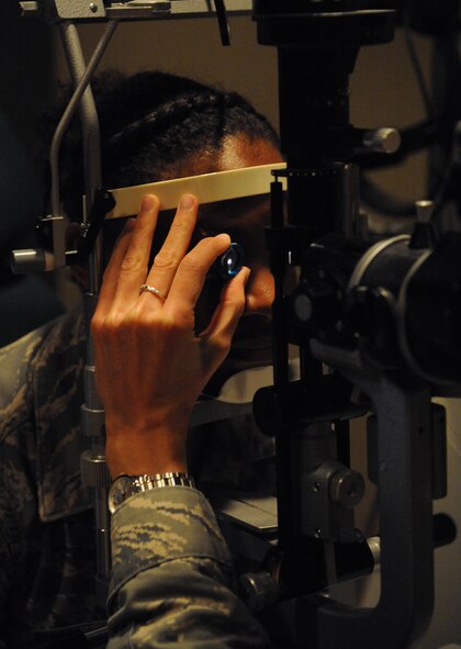 Capt. Lauren Pfendler, 2nd Aerospace Medical Squadron optometrist, looks at Airman 1st Class Jessica Bicy, 2nd Comptroller Squadron financial services technician, eye with a slit lens on Barksdale Air Force Base, La., March 26, 2014. The slit lens is used to get a close look at the eye. A standard eye exam will consist of a visual acuity check used to determine a change in vision and other procedures to ensure the patient's eyes are healthy and free of disease. (U.S. Air Force photo/Senior Airman Benjamin Gonsier)