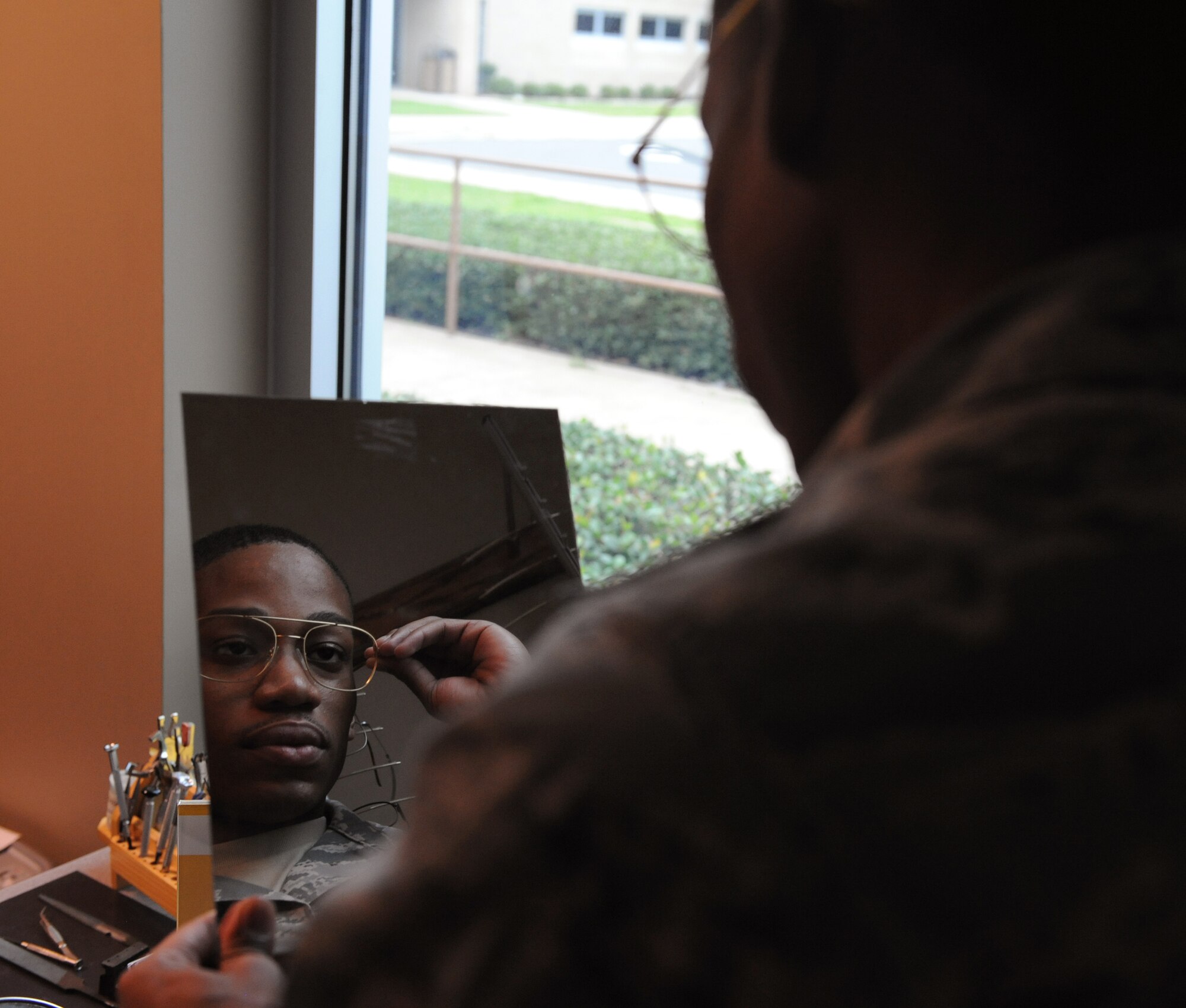 Airman 1st Class Phillip Scott, 20th Bomb Squadron aviation resource manager, looks at himself in a mirror while trying on a glasses frame on Barksdale Air Force Base, La., March 26, 2014. The Optometry Clinic offers a wide variety of frames for service members. (U.S. Air Force photo/Senior Airman Benjamin Gonsier)