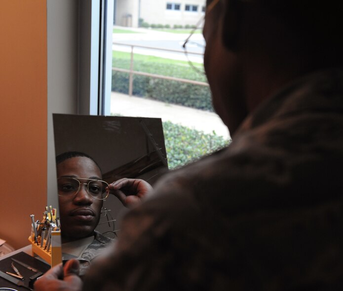 Airman 1st Class Phillip Scott, 20th Bomb Squadron aviation resource manager, looks at himself in a mirror while trying on a glasses frame on Barksdale Air Force Base, La., March 26, 2014. The Optometry Clinic offers a wide variety of frames for service members. (U.S. Air Force photo/Senior Airman Benjamin Gonsier)