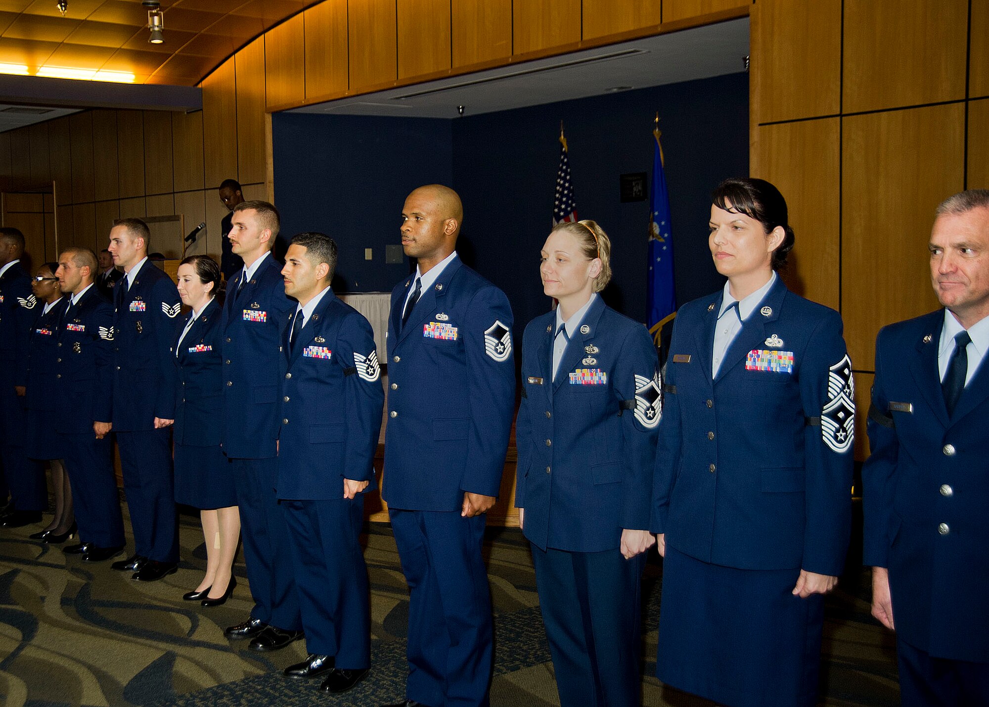 April promotes stand at attention at the conclusion of the monthly promotion ceremony March 31 at the Horizons Community Activity Center. (U.S. Air Force photo by Airman 1st Class Dustin Mullen)