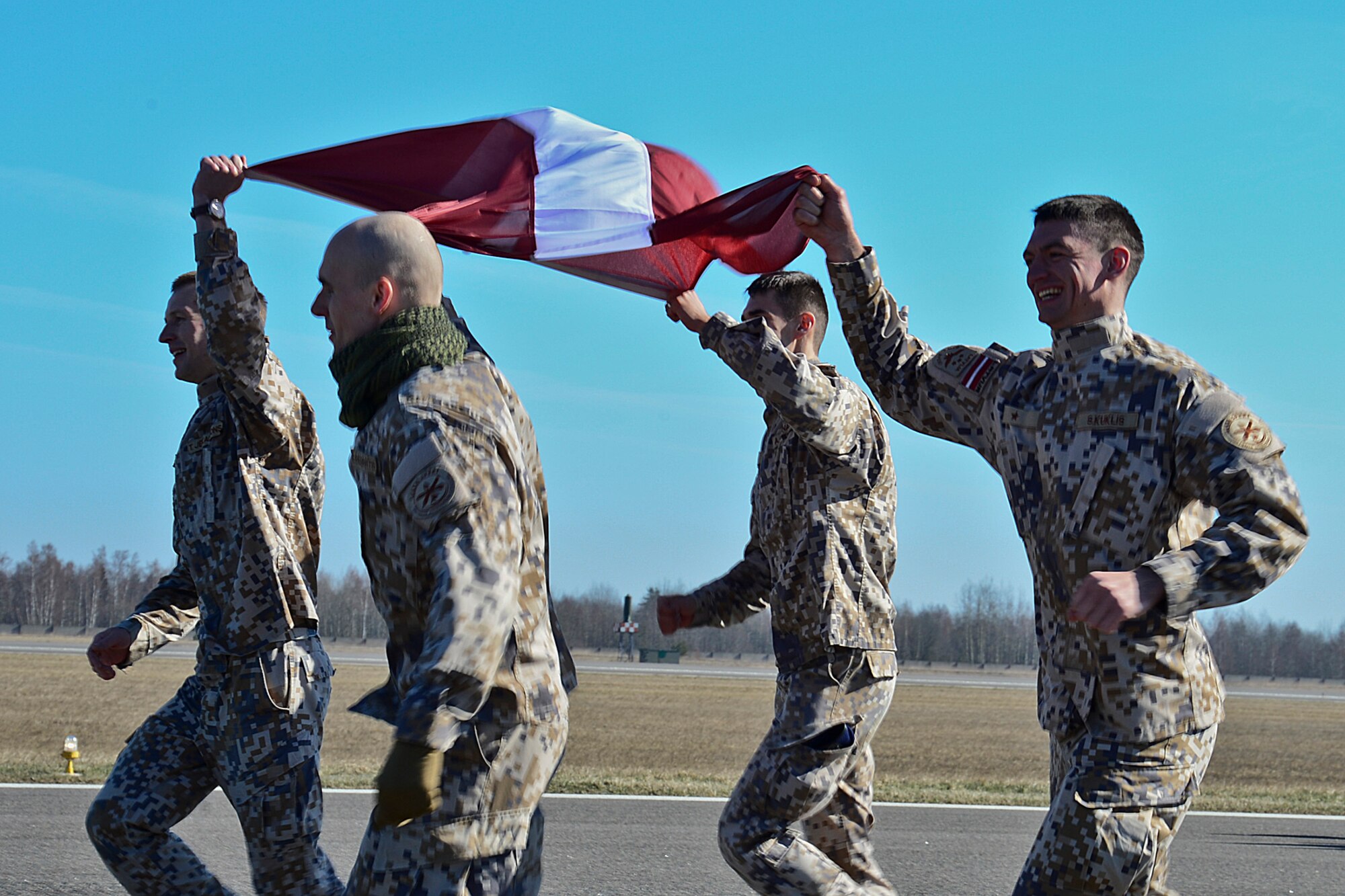 Members of the Latvian air force run during ‘Runway Run 2014,’ in celebration of the 10-year anniversary of Lithuania joining NATO and the Baltic Air Policing mission at Šiauliai Air Base, Lithuania, March 28, 2014. For the past 10 years, air forces from across NATO have shared the responsibility of patrolling the skies over Estonia, Latvia and Lithuania contributing to a safe and stable future. (U.S. Air Force photo by Airman 1st Class Dana J. Butler/Released)
