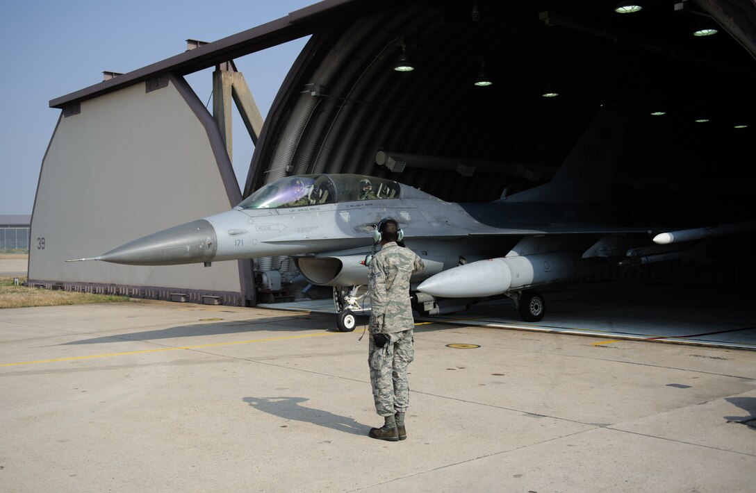 Senior Airman John Smith, 8th Aircraft Maintenance Squadron crew chief, gives the final salute to Capt. Joshua Bibb, 35th Fighter Squadron pilot, and U.S. Army Command Sgt. Maj. John Troxell, United States Forces Korea command sergeant major, as they taxi for a familiarization flight at Kunsan Air B ase, Republic of Korea, Mar. 28, 2014. Troxell visited with Kunsan’s Airmen and saw how the Wolf Pack stays prepared and ready to fight tonight both on the ground and in the air.  (U.S. Air Force photo by Senior Airman Armando A. Schwier-Morales/Released)