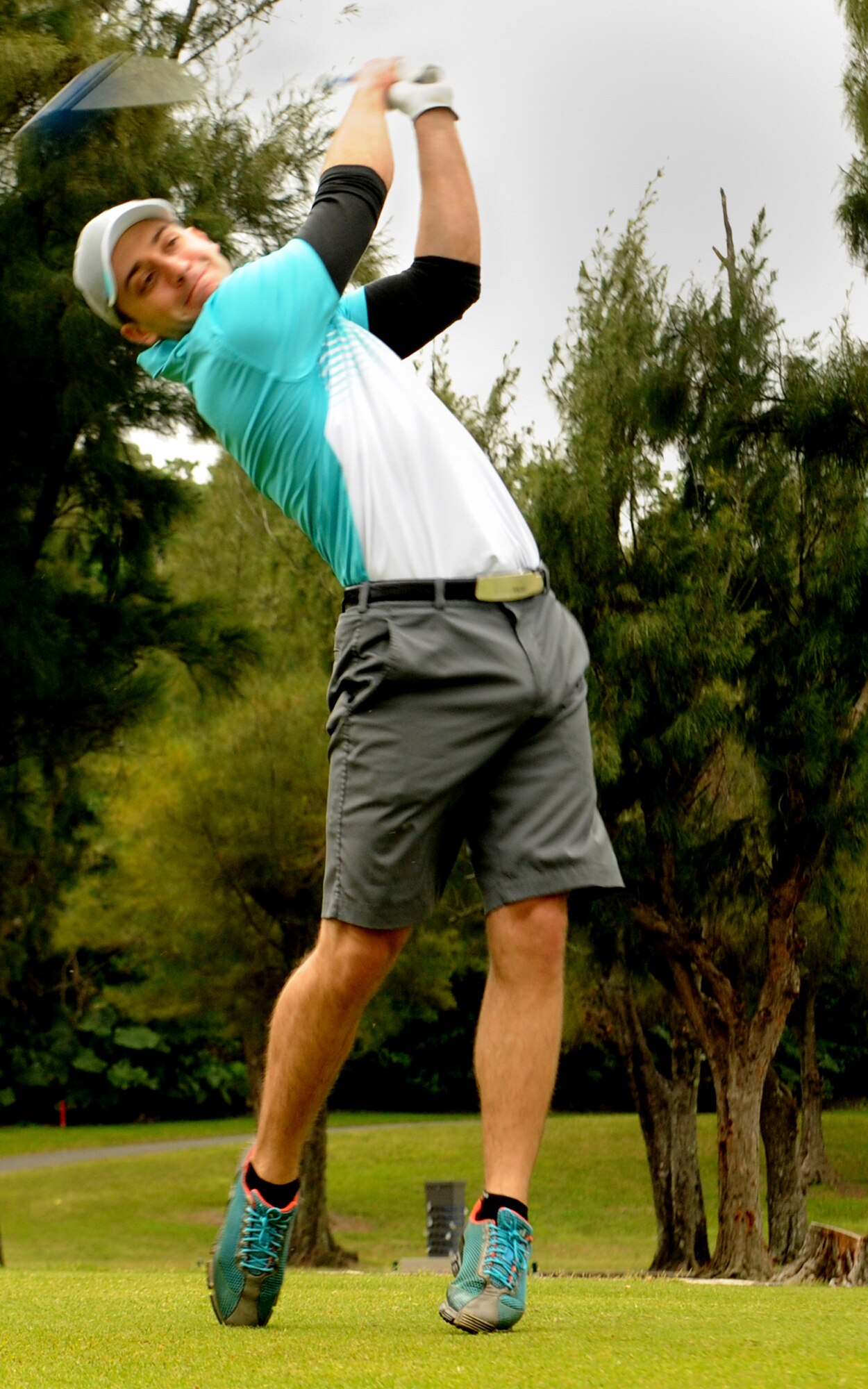 U.S. Air Force Staff Sgt. Kyle Storako, 18th Civil Engineer Squadron aircraft hydrolics technician, follows through with his swing during the 2014 Sexual Assault Program and Response program golf tournament on Kadena Air Base, Japan, March 28, 2014. Storako is a golf veteran with 20 years of experience and has been a victim advocate for Kadena's SAPR program for six months. He plans to continue volunteering for the duration of his tour here. (U.S. Air Force photo by Airman 1st Class Zackary Henry)