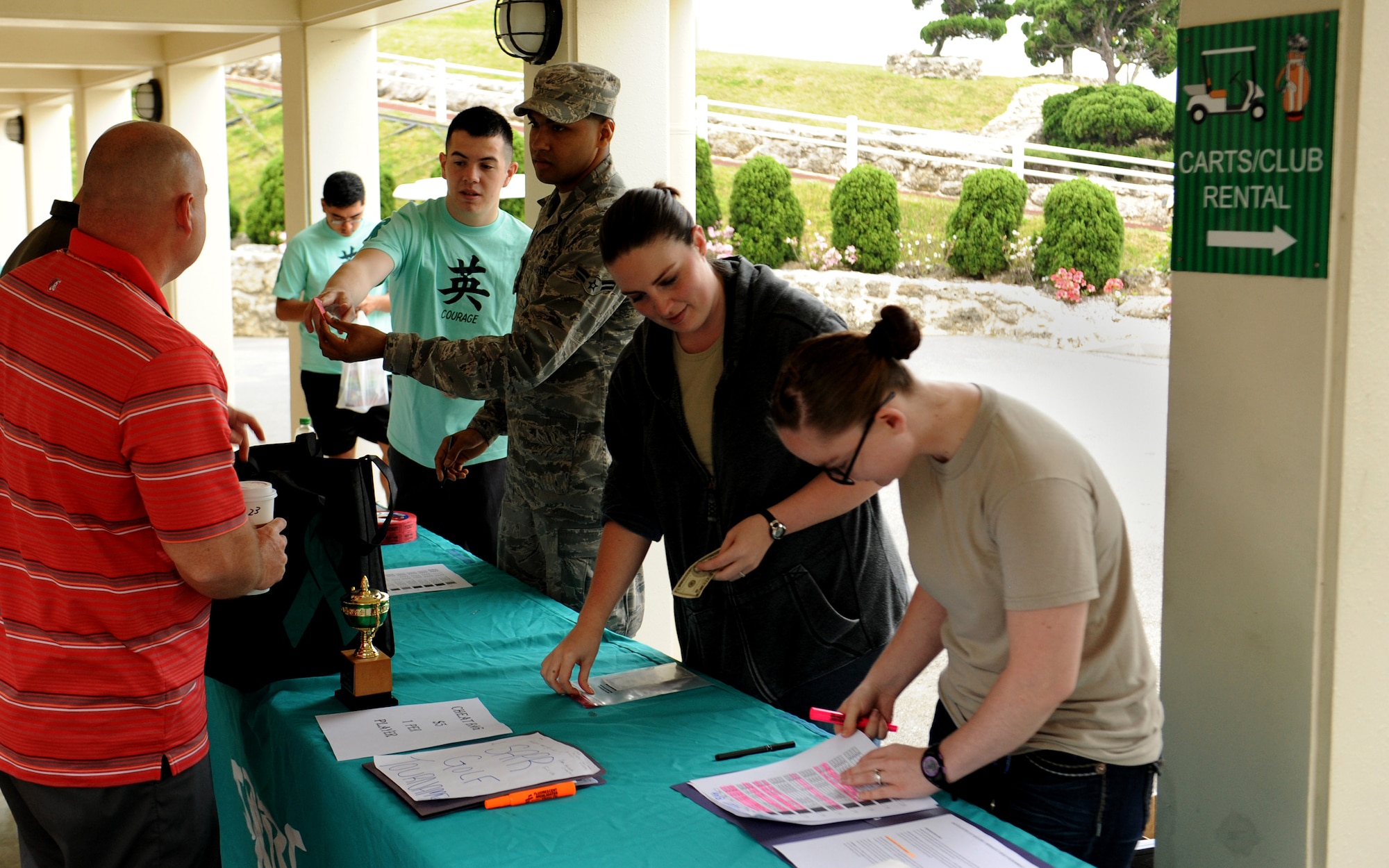 The Kadena Sexual Assault Prevention and Response program team assists golfers signing in to participate in the 2014 SAPR Golf Tournament on Kadena Air Base, Japan, March 28, 2014. Since 2004, the SAPR program has sponsored Sexual Assault Awareness Month to raise awareness against sexual assault in the military. (U.S. Air Force photo by Airman 1st Class Zackary Henry)